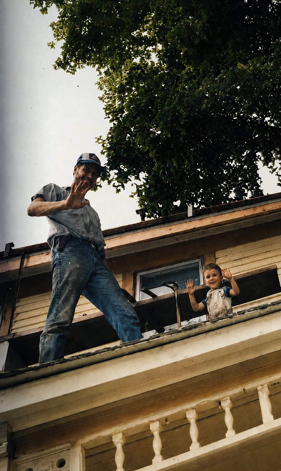 Russell Landes and his young son Brian waving while working on the old farmhouse